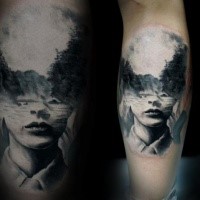 Schwarzes Bein Tattoo des menschlichen Gesichts mit Bergwald