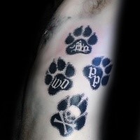 Black ink modern style side tattoo of big dog paw prints stylized with various symbols