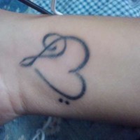 Black ink music heart tattoo on wrist