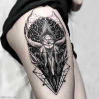Black ink mystical thigh tattoo of large animal skull with mysterious ornaments