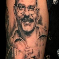Tatuaje en el brazo, hombre sonriente en gafas