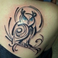 Black ink owl tattoo on shoulder blade