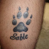Schwarze Tinte Pfotenabdruck des Hundes denkwürdiges Tattoo am Bein