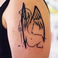Black ink silhouette angel tattoo on shoulder