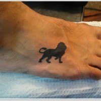 Black ink silhouette lion tattoo on foot