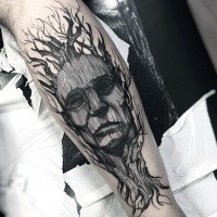 Black ink strange looking engraving style tattoo of old tree with mans face