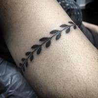 Black ink tattoo of bracelet shaped plant