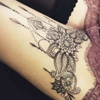 Black ink thigh tattoo of floral ornaments by Caro Voodoo