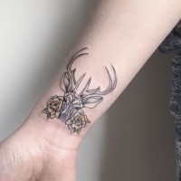 Black ink tiny wrist tattoo of deer with flowers