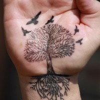 Tatuaje en la palma, árbol con raíces largas y aves, color negro
