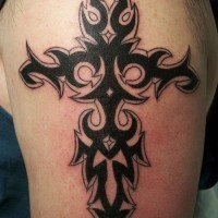 Tatuaje en el brazo,
cruz tribal, tinta negra