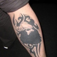 Tatuaje en la pierna, rostro de vikingo, estilo tribal, tinta negra