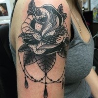 Black ink typical looking shoulder tattoo of big rose with jewelry