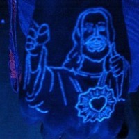 Black light jesus tattoo on the fist