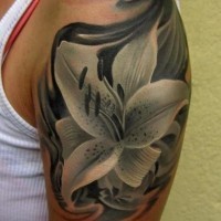 Black lily tattoo on shoulder
