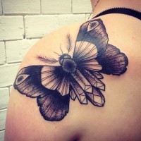 Black moth tattoo on shoulder