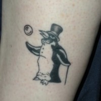 Tatuaje en la pierna,
pingüino de circo en sombrero de copa y con bola