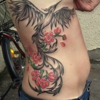 Black phoenix and flowers tattoo on ribs