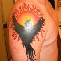 Black phoenix and sun tattoo on arm