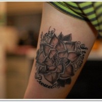 Tatuaje en el brazo, loto negro blanco con inscripción