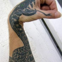 Schwarze Schlange mit grünen Augen Tattoo am Arm