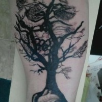 Black tree grown from heart tattoo on arm