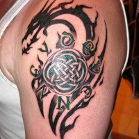 Tatuaje en el brazo,
dragón negro tribal