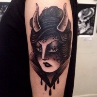 Blackwork style detailed shoulder tattoo of woman with horns