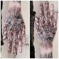 Blackwork style hand tattoo of human eye with tree branches