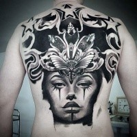 Blackwork style impressive looking back tattoo of woman face with big butterfly and stars