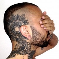 Blackwork style large head and neck tattoo of various flowers