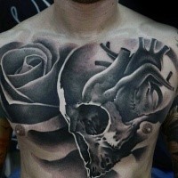 Tatuaggio sul petto di un teschio umano in stile blackwork combinato con rosa e cuore