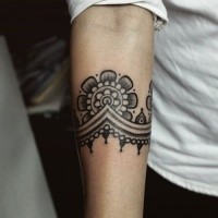 Blackwork style simple looking forearm tattoo of nice floral ornament