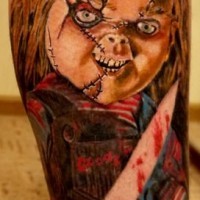 Horrortattoo aus dem Film mit  blutdürstigigem Chucky auf dem Bein