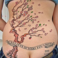 Tatuaje en la espalda,
árbol fino con flores y escrito