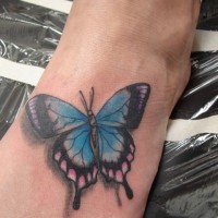 Tatuaje  de mariposa azul claro volumétrica en el pie