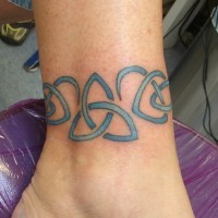 Blue celtic symbols band tattoo on ankle