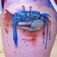 Blue crab tattoo standing on sand