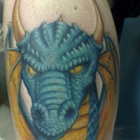 Tatuaje en el brazo, cabeza de dragón cornudo de color azul amarillo