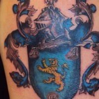 Blue family crest tattoo on shoulder