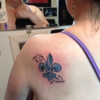 Tatuaje en el hombro,
 flor de lis azul pequeña
