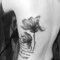 Tatuaje en el costado,  dos flores delicadas y inscripción larga
