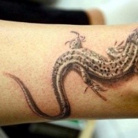 Breathtaking real photo like realism style colored ankle tattoo of small lizard