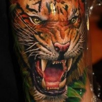 Breathtaking realism style colored arm tattoo of roaring tiger face