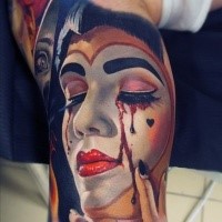 Breathtaking realism style colored biceps tattoo of crying bloody tears Joker woman face