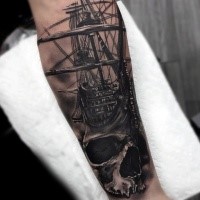 Breathtaking realism style colored forearm tattoo of sailing ship with human skull
