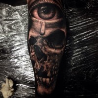 Breathtaking very detailed human skull tattoo on forearm combined with mystic eye