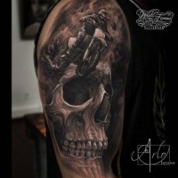 Breathtaking very detailed shoulder tattoo of human skull with bike rider
