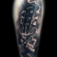 Brilliant music themed black and white Gibson guitar parts tattoo on arm