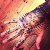 Buddhistischsn Gesicht Tattoo am Handgelenk